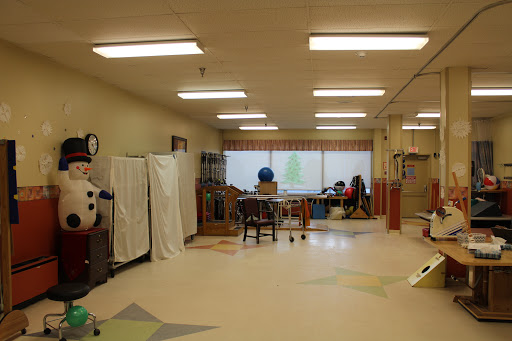 A spacious therapy room equipped with various tools and furniture for learning and rehabilitation.