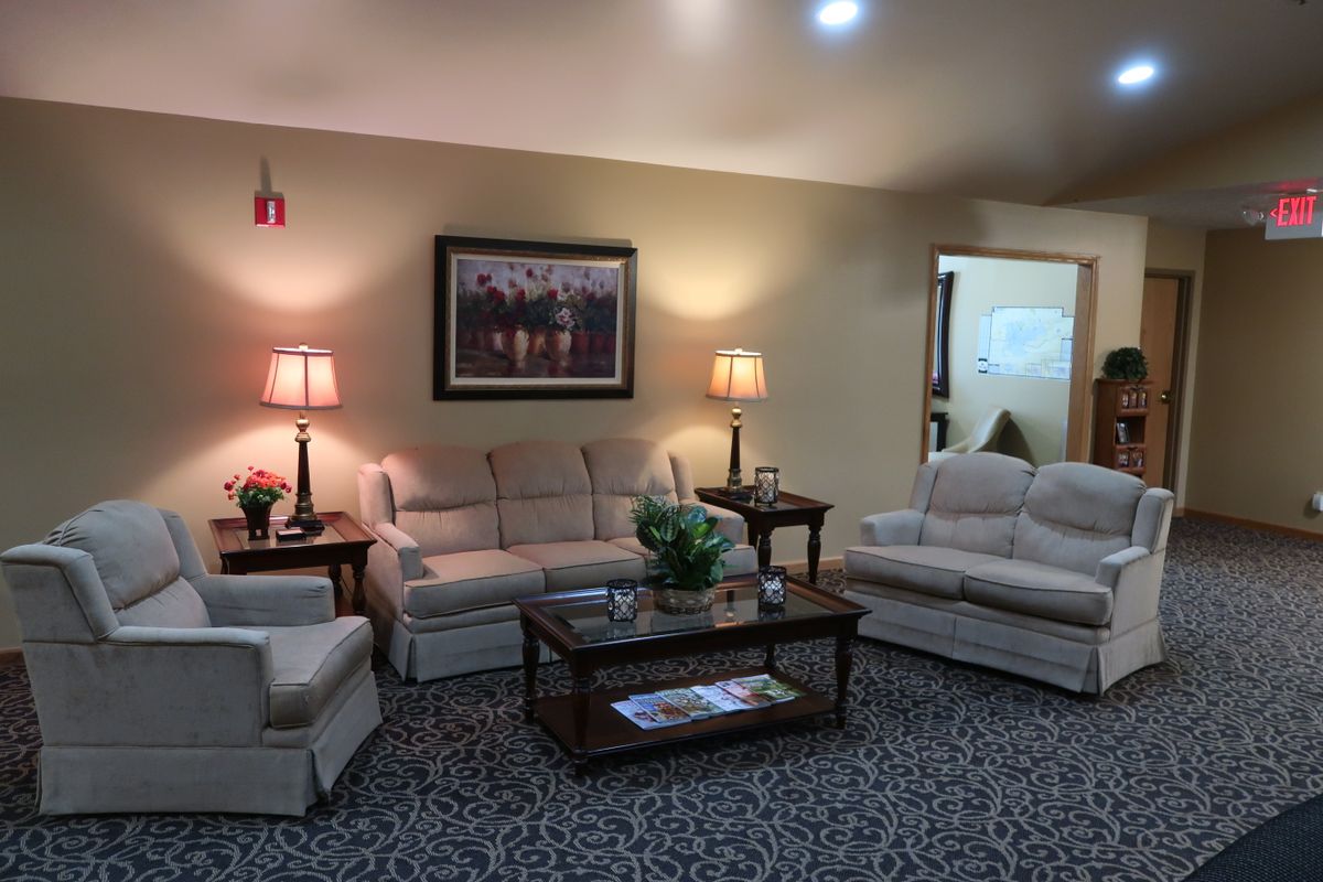 A cozy living room with sofas, lamps, and a central coffee table.