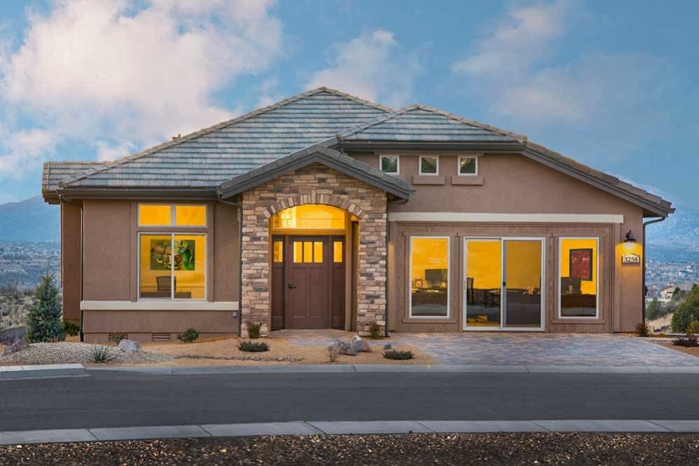 A modern residential house with a stone facade during the evening.