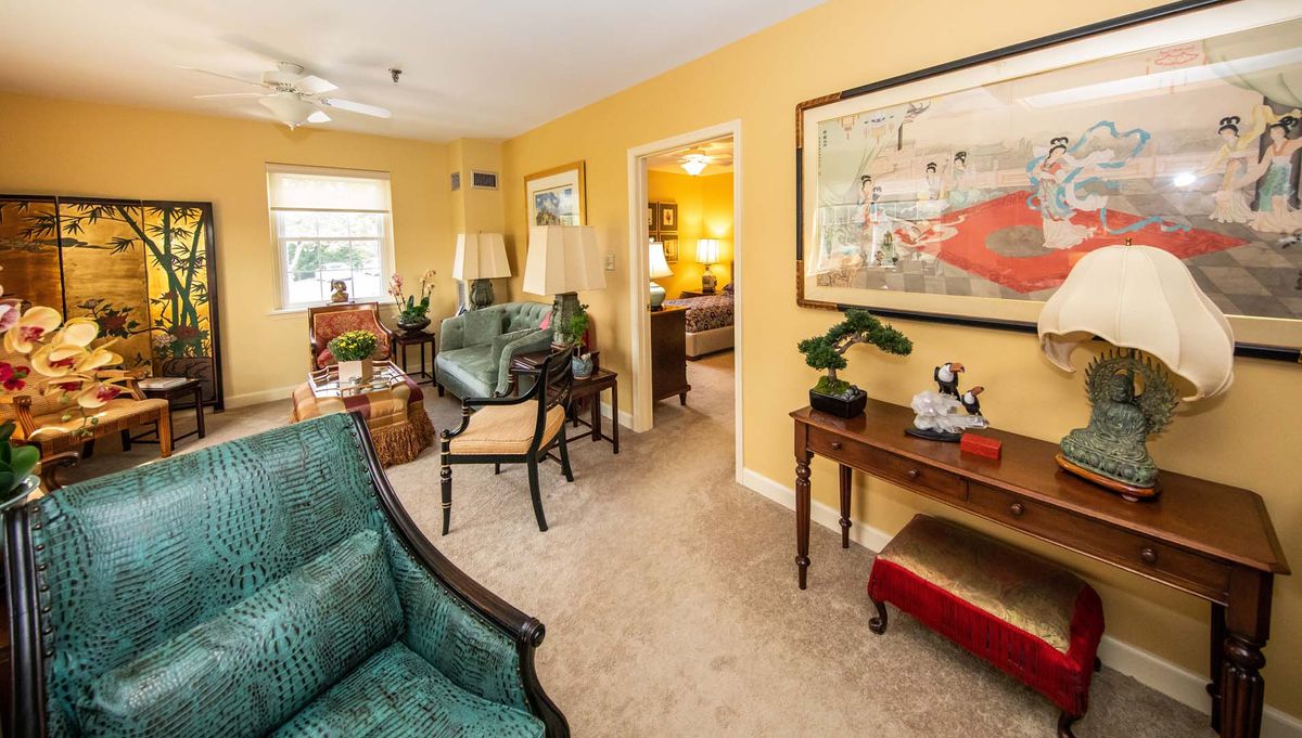 A cozy living room with yellow walls, featuring comfortable seating and tasteful decor.