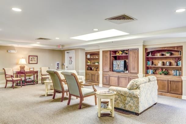 A cozy and well-furnished living room with sofas, chairs, a television, and built-in shelves.