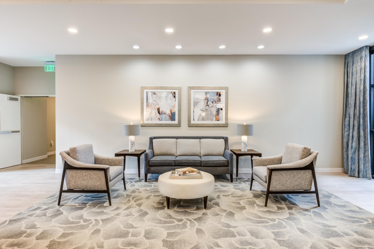 A modern living room with a central sofa, chairs, and elegant decor.