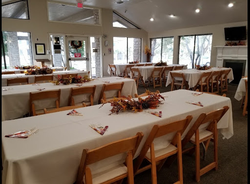 A spacious dining area set up for an event, featuring neatly arranged tables and chairs with a bright, inviting atmosphere.