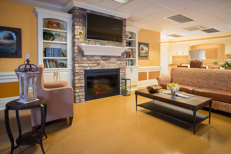 A cozy living room with a fireplace, bookshelves, and comfortable seating.