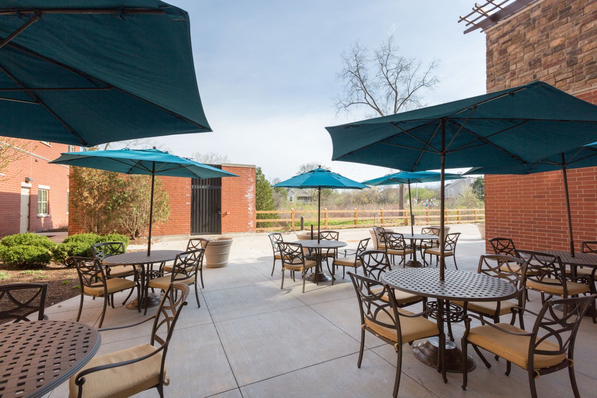 An outdoor patio with tables and umbrellas on a sunny day.