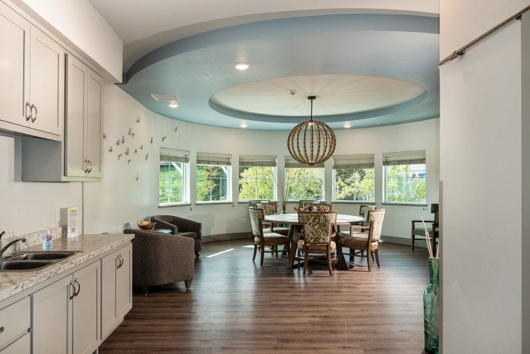 A modern dining room with a round table, large windows, and elegant lighting.
