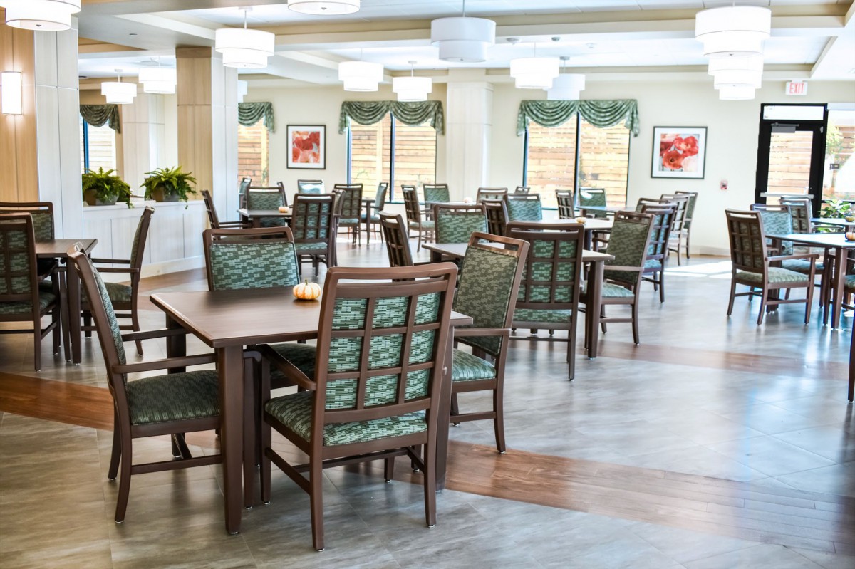 A well-lit dining area with neatly arranged tables and chairs.