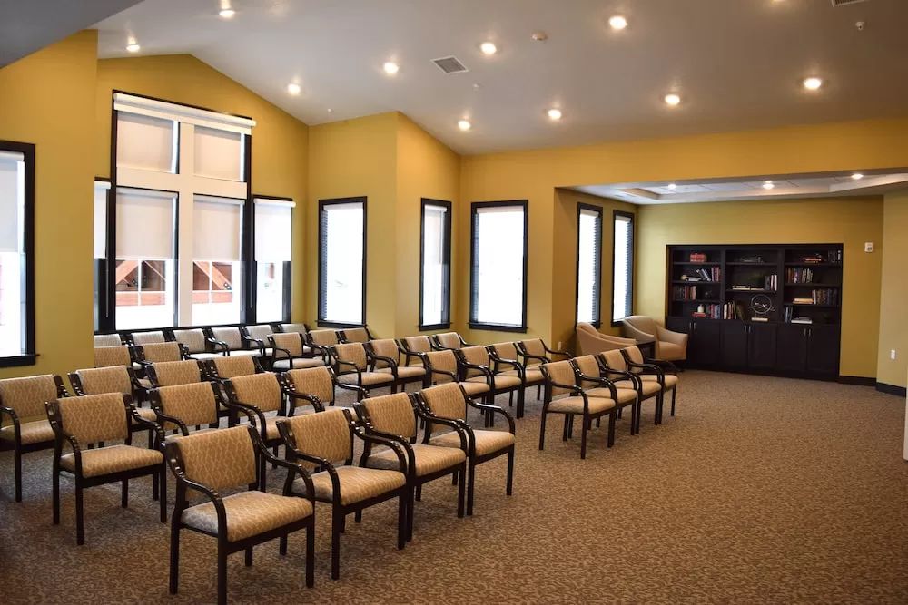 A well-lit conference room with rows of chairs arranged for a meeting.