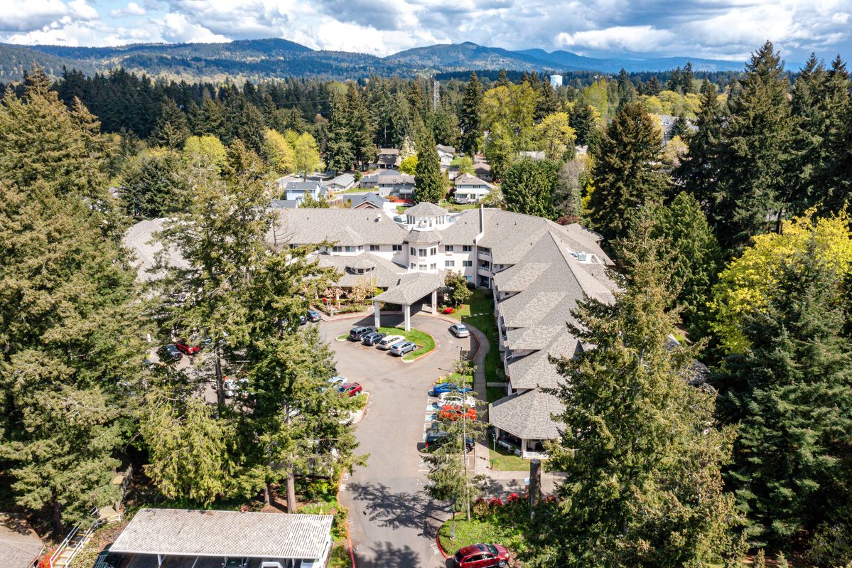 Aerial view of a large building surrounded by trees and natural landscape.