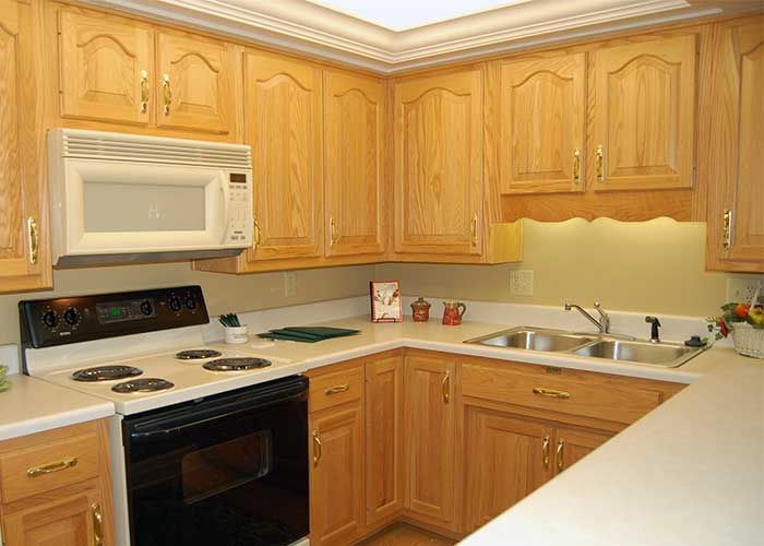 A modern kitchen with wooden cabinets and standard appliances.