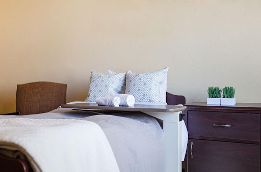 A cozy bedroom setup featuring neatly arranged pillows and a bedside table.