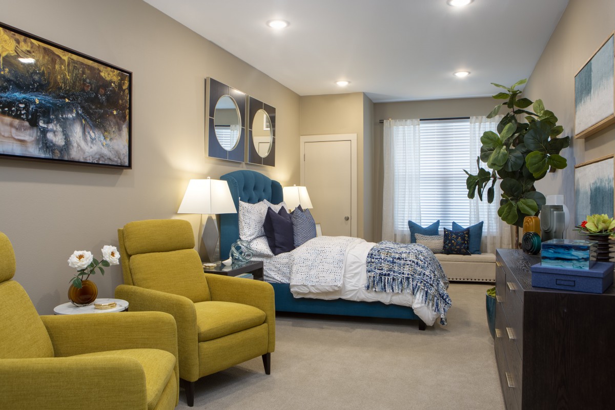 A modern bedroom featuring vibrant yellow chairs and a stylishly designed bed.