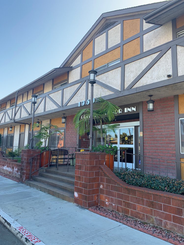 A tudor-style building with brick accents and an entrance featuring outdoor seating.