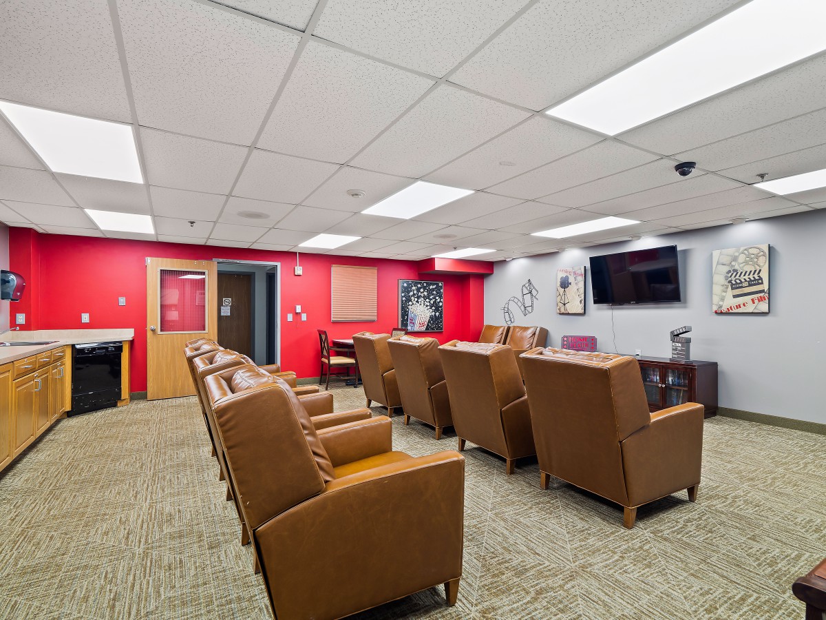A spacious conference room with comfortable seating and a television on the wall.