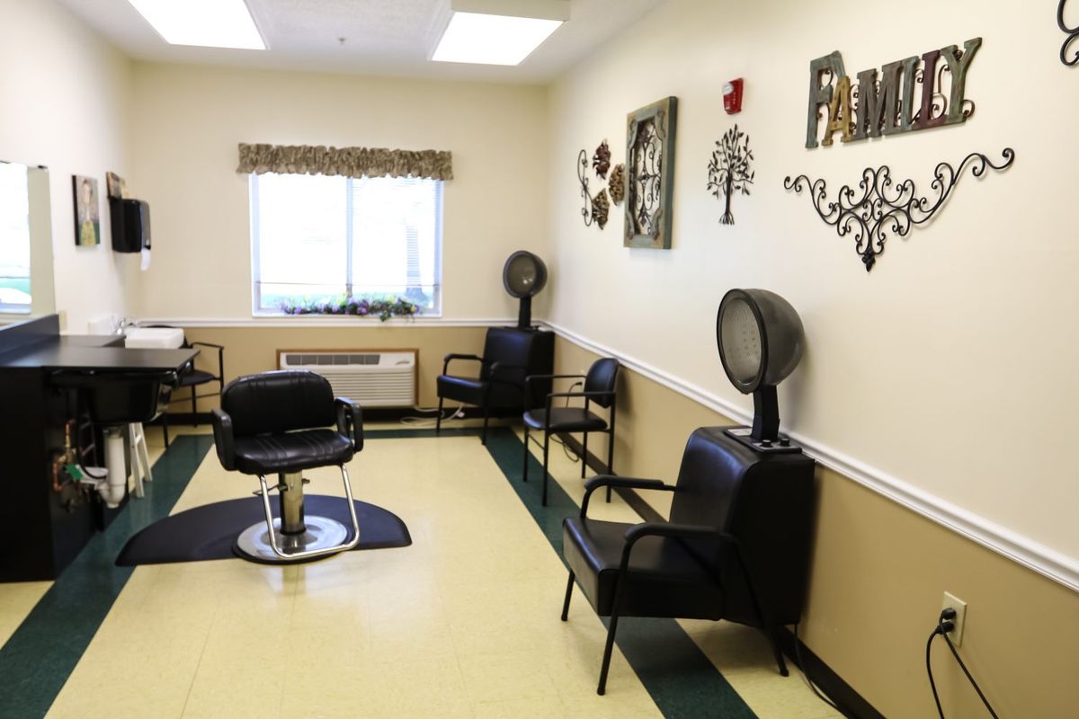 An interior view of a hair salon with chairs and hair dryers.