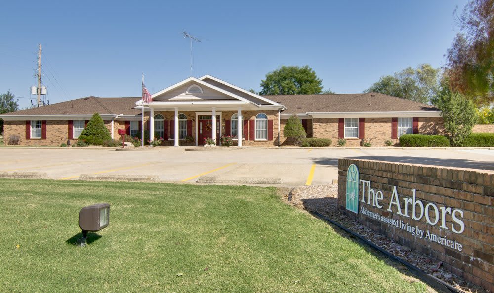 A single-story brick building with a prominent entrance sign, surrounded by a neatly maintained lawn.