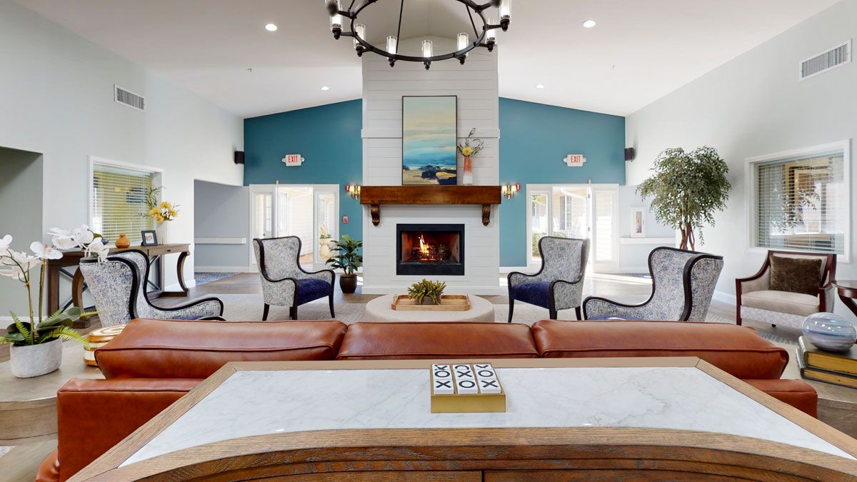 A stylish living room featuring a central fireplace, elegant furniture, and blue accent walls.