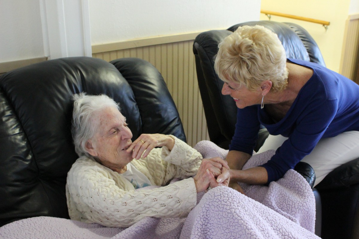 An older adult receiving care and support from a companion.