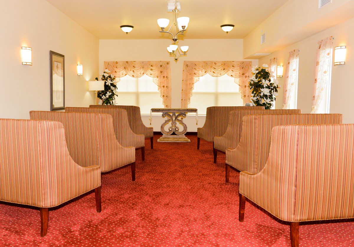 A cozy waiting area with lined-up chairs, warm lighting, and large windows.