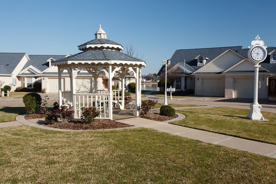 A charming gazebo in a suburban neighborhood surrounded by well-kept lawns and houses.