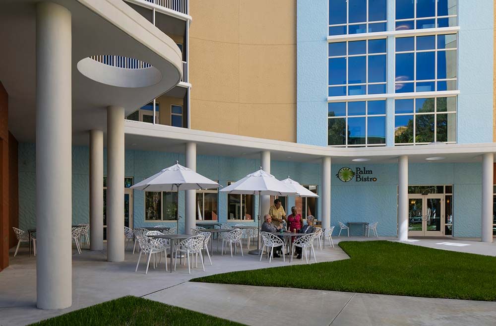 Modern building with outdoor seating under umbrellas.