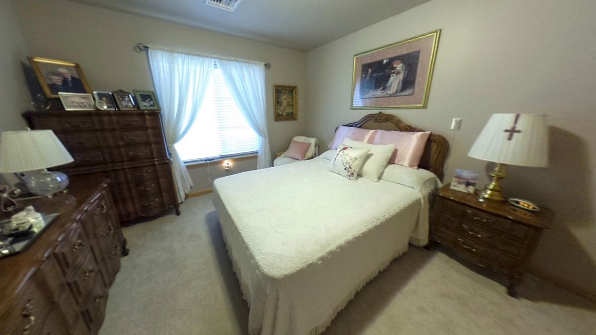 A cozy bedroom with a neatly made bed and soft lighting.
