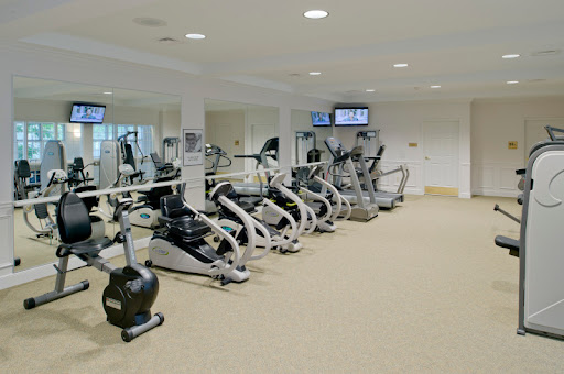 A well-equipped gym featuring various cardio machines.