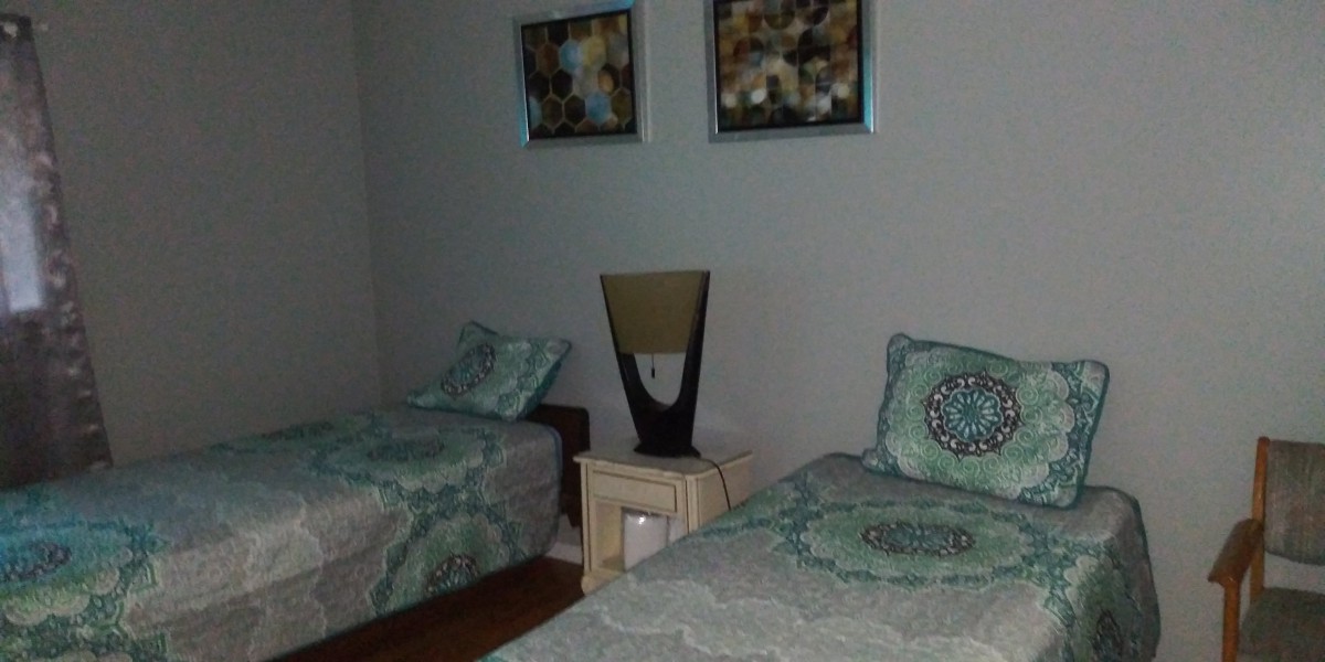 A cozy bedroom with twin beds, a nightstand, and decorative artwork on the wall.