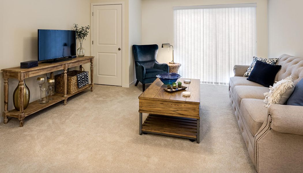 A cozy living room with a coffee table, armchair, and TV setup.