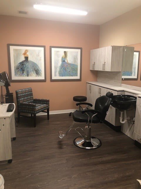 Modern hair salon interior with styling chairs, sink, and artwork on the walls.