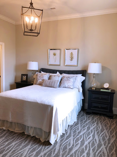 A cozy and elegant bedroom featuring a neatly made bed, stylish nightstands with lamps, and decorative wall art.
