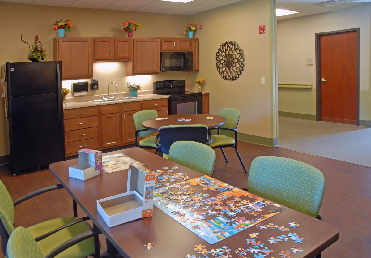 A cozy kitchen and dining area featuring a table with a puzzle in progress.