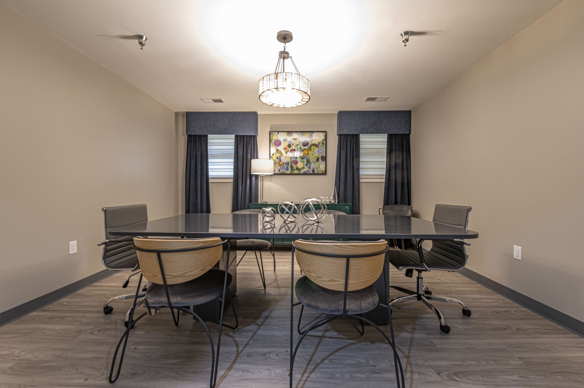 A modern conference room featuring a large table, comfortable chairs, and contemporary decor.
