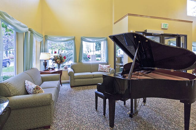 A cozy living room featuring a grand piano and comfortable seating.