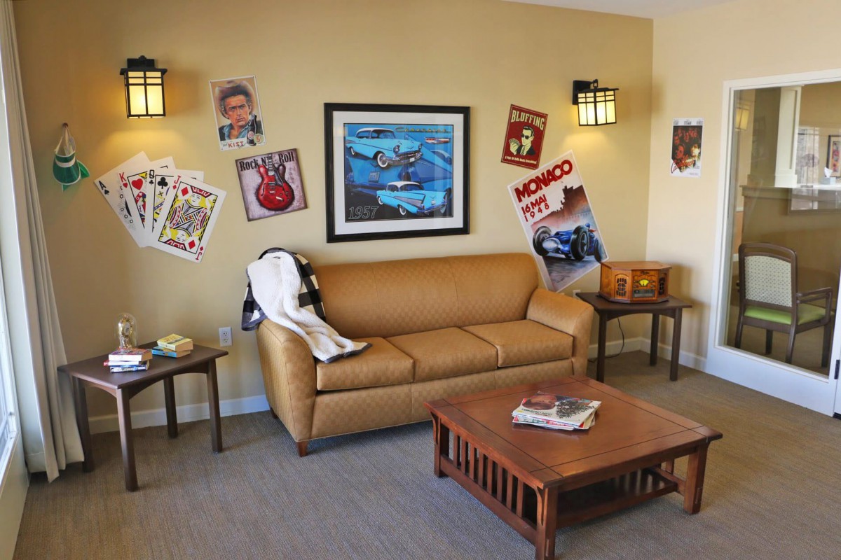 A retro-themed living room featuring vintage posters and a comfortable sofa.