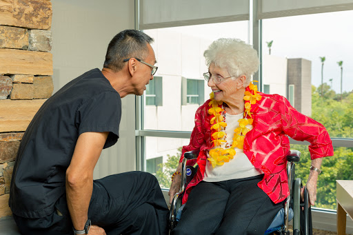 A heartfelt moment of connection between a caregiver and an elderly woman in a vibrant setting.