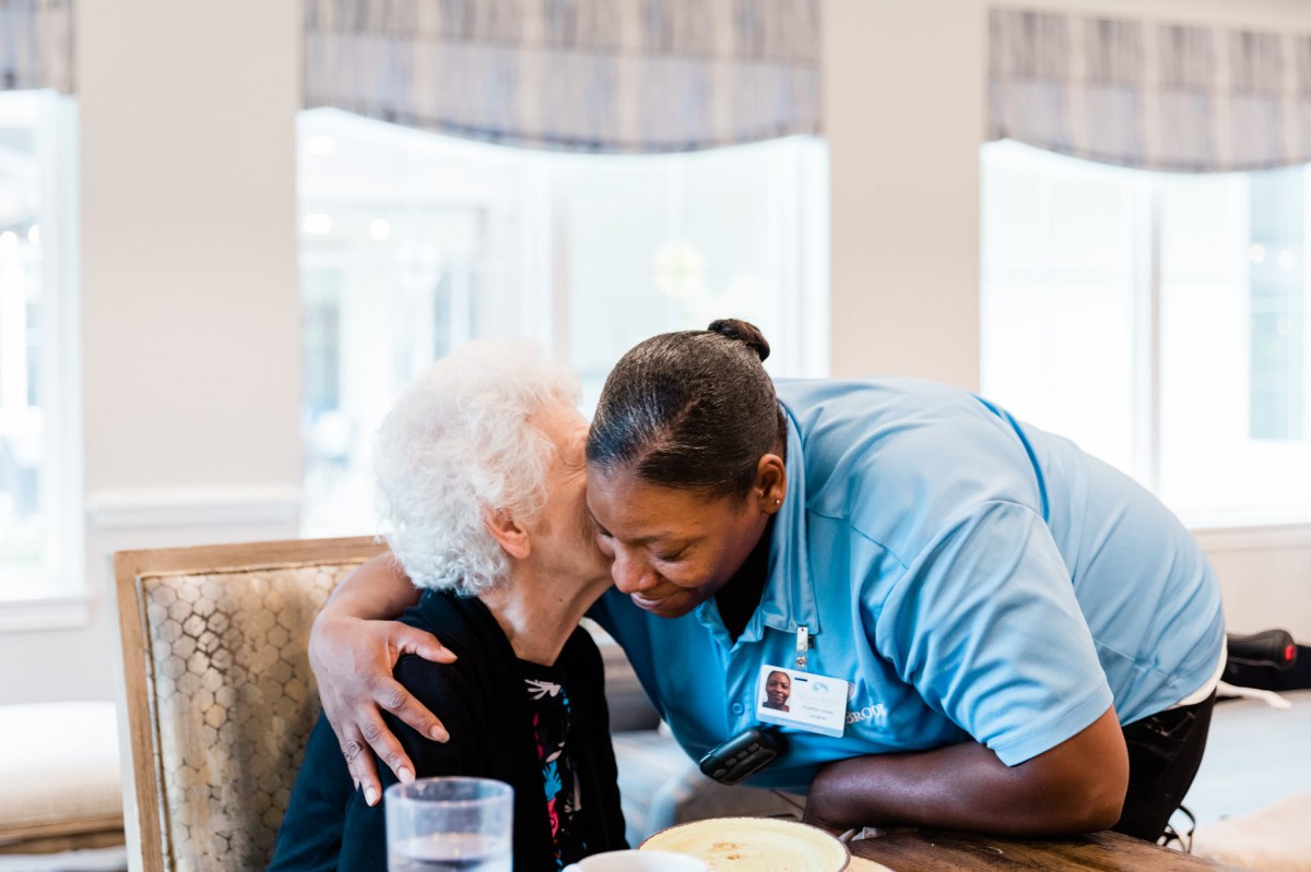 A healthcare worker shares a warm moment with an elderly person, showcasing compassion and care.