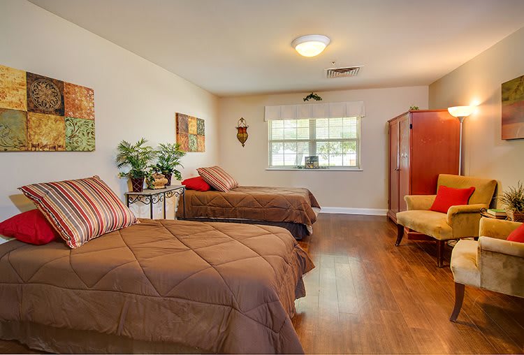 A cozy bedroom with twin beds, a wooden floor, and decorative accents.