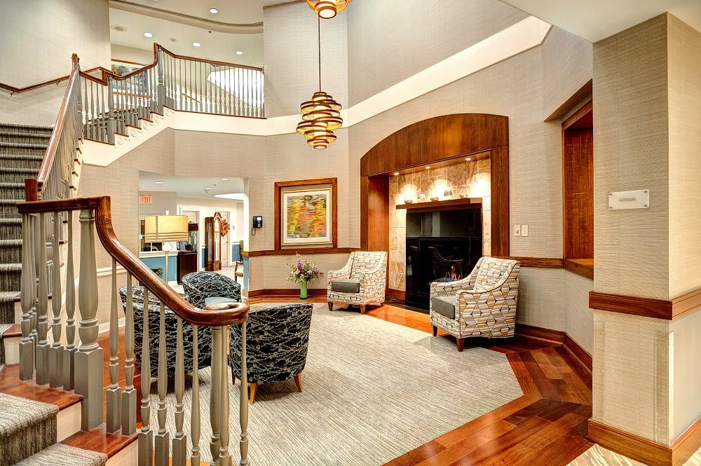 A beautifully designed living room with elegant furnishings and a sweeping staircase.