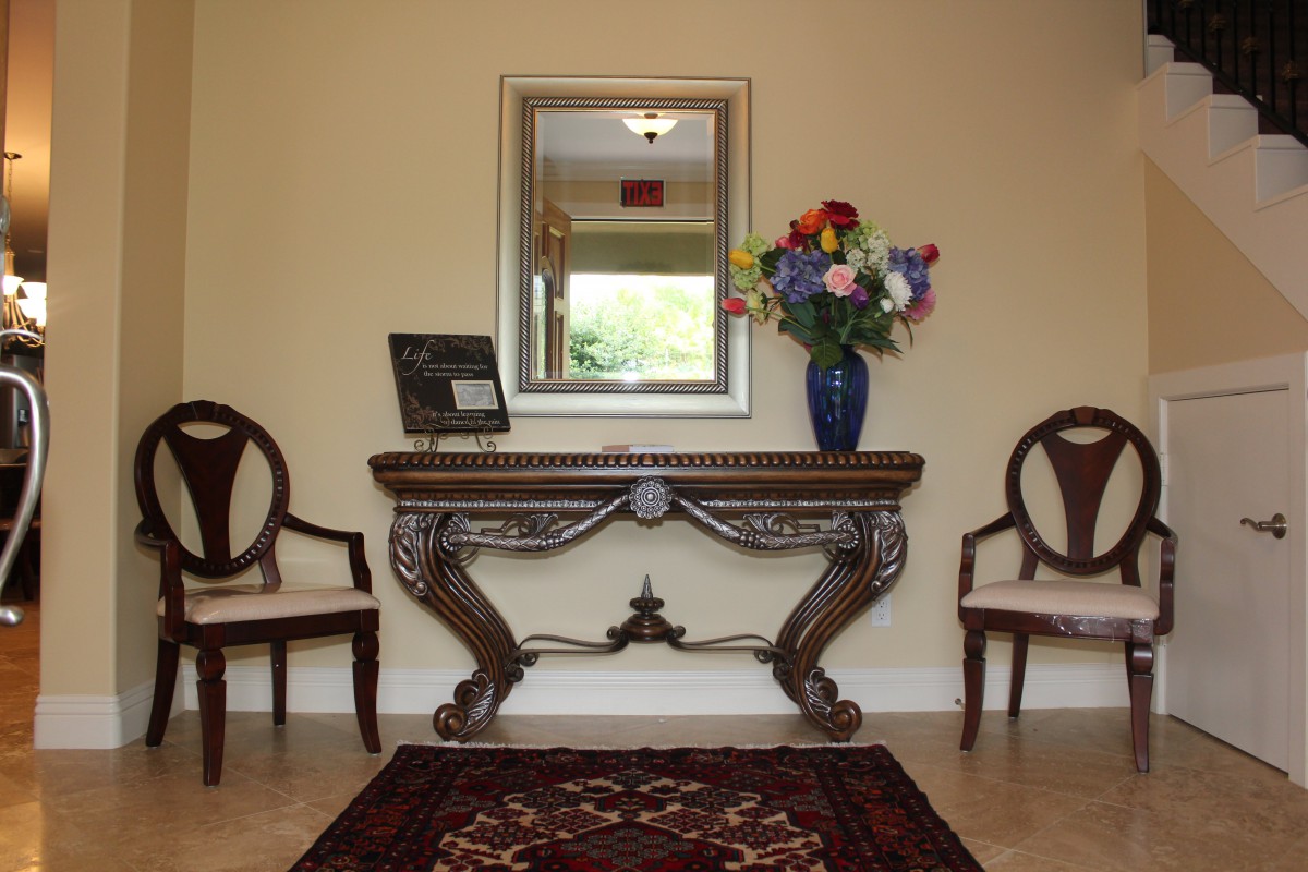 Elegant hallway with a decorative console table, mirror, and floral arrangement.
