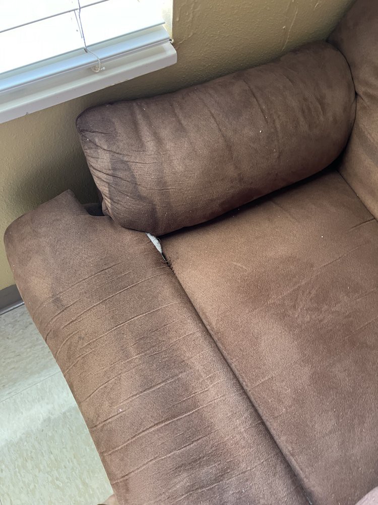Brown upholstered sofa near a window in a living room.