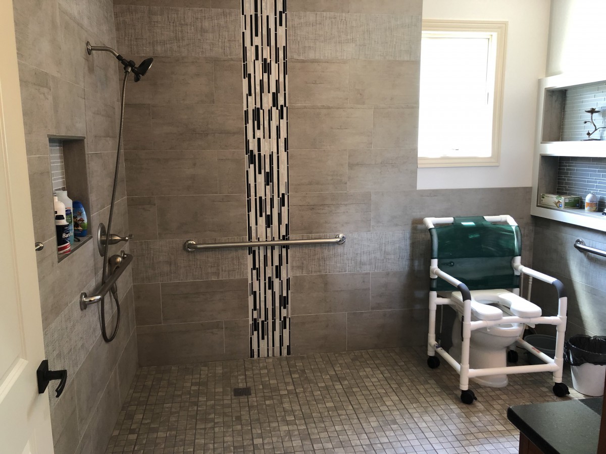 An accessible bathroom with a walk-in shower and a shower chair.