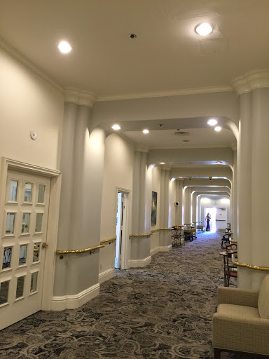 A well-lit corridor featuring decorative columns and patterned carpet.