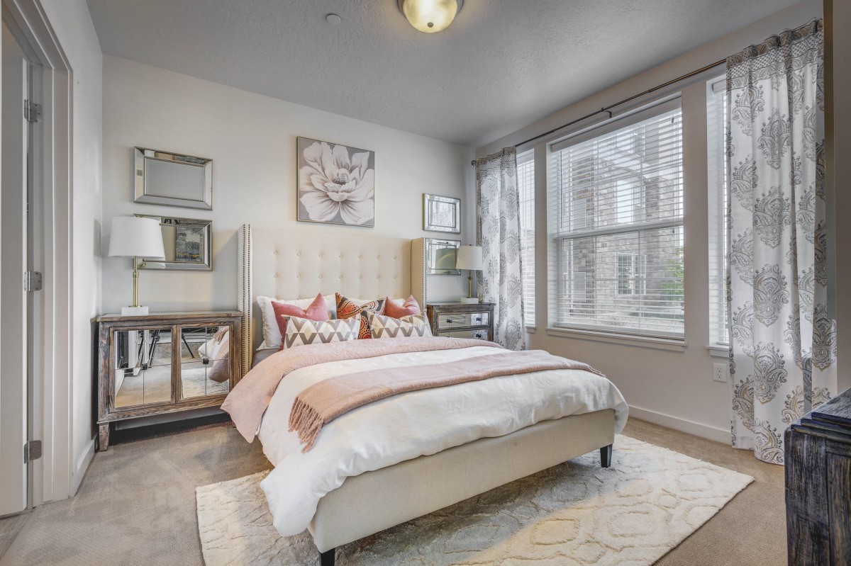 A modern and cozy bedroom with ample natural light and stylish decor.