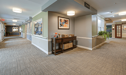 A well-lit, modern hallway with a console table and artwork on the wall.