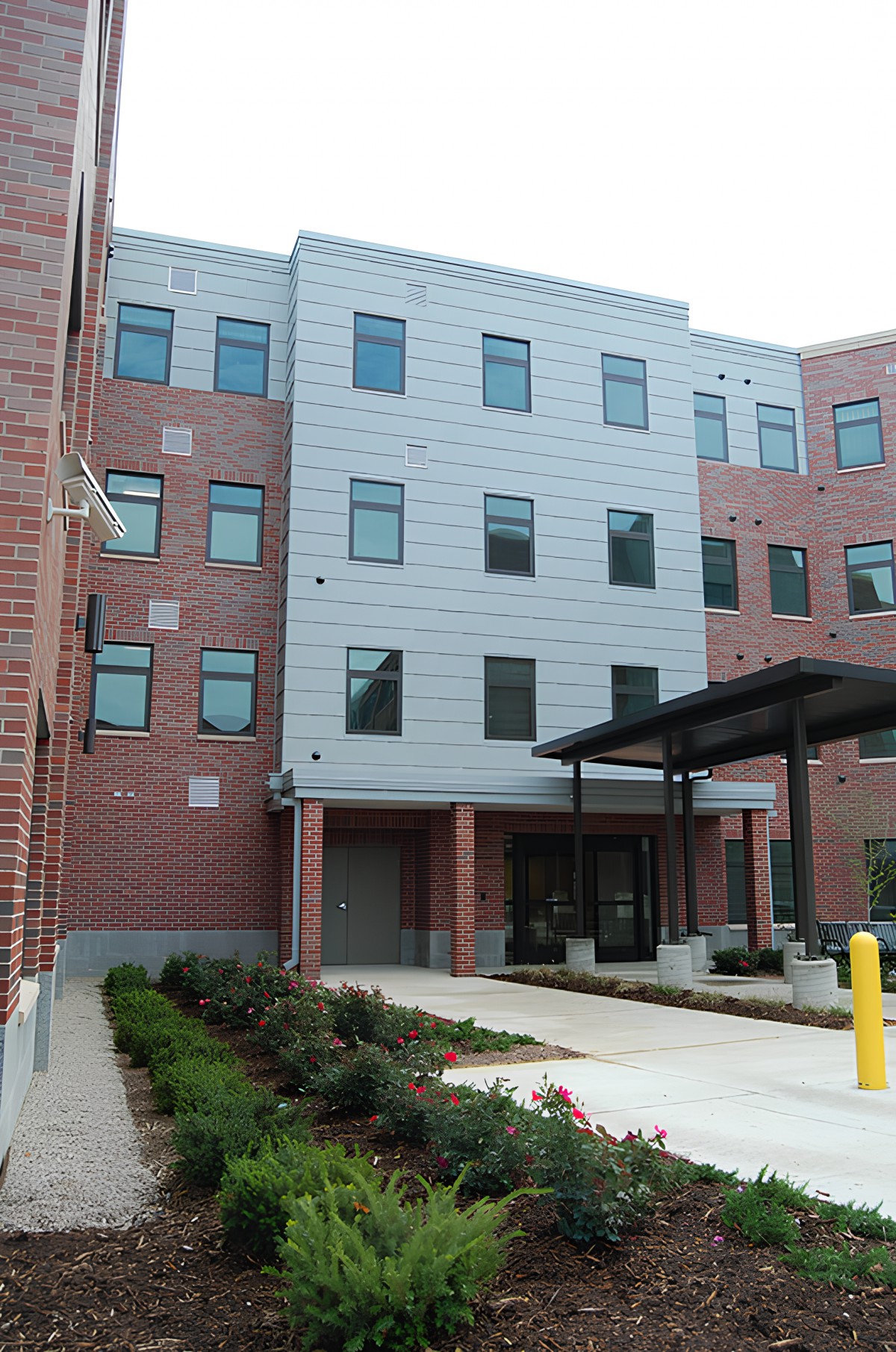A modern residential building with brick and metal facade.