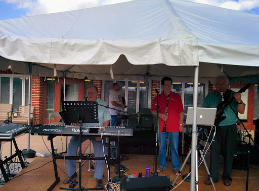 A band performing live under a tent at an outdoor event.