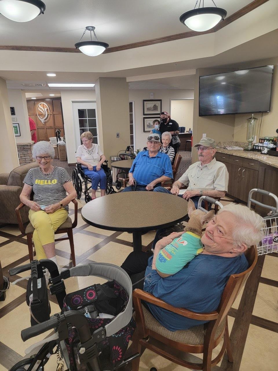 A group of elderly individuals seated in a community room.
