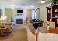 A cozy living room with a fireplace, piano, and comfortable seating.
