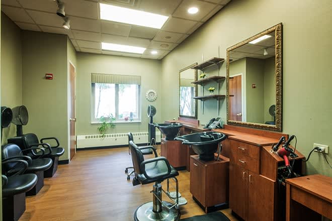 A modern hair salon interior with styling chairs, mirrors, and sinks.